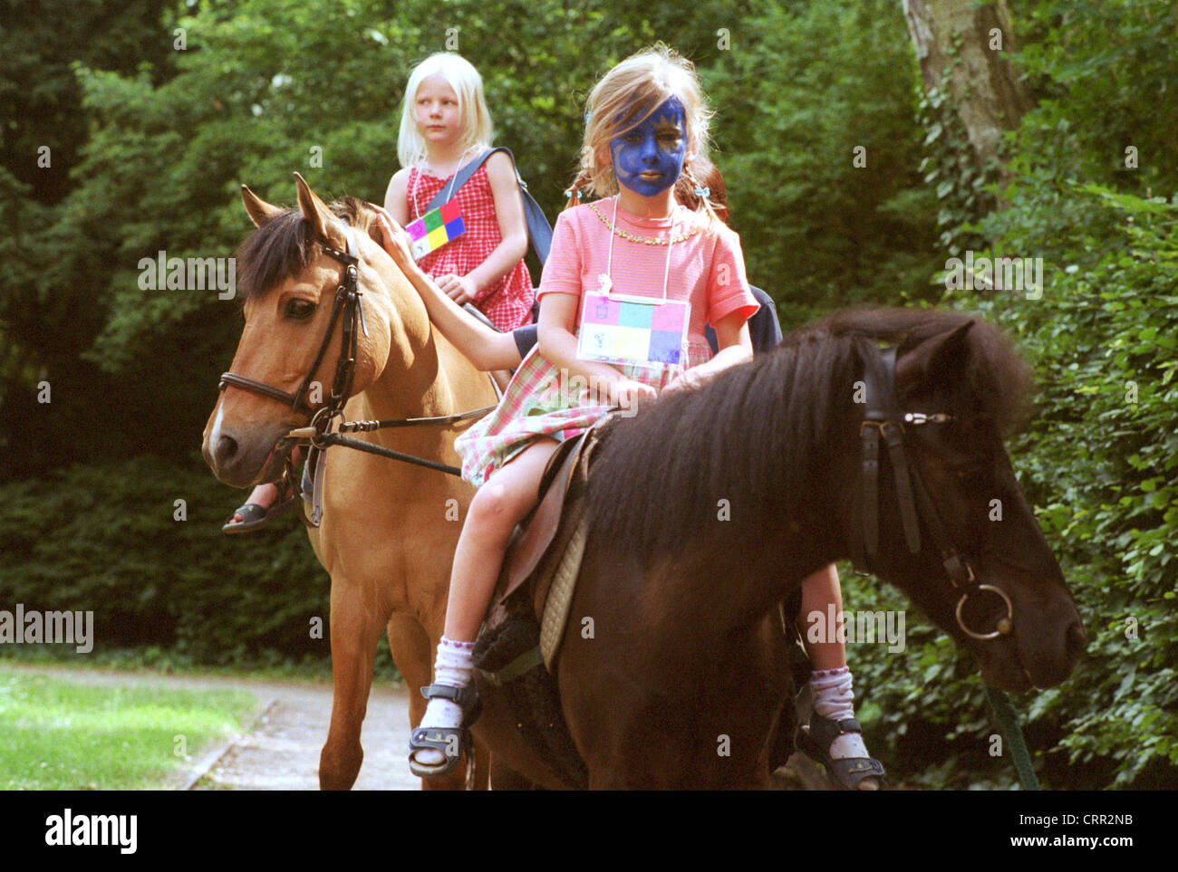 Zwei kleine Mädchen reiten auf Ponys Stockfoto