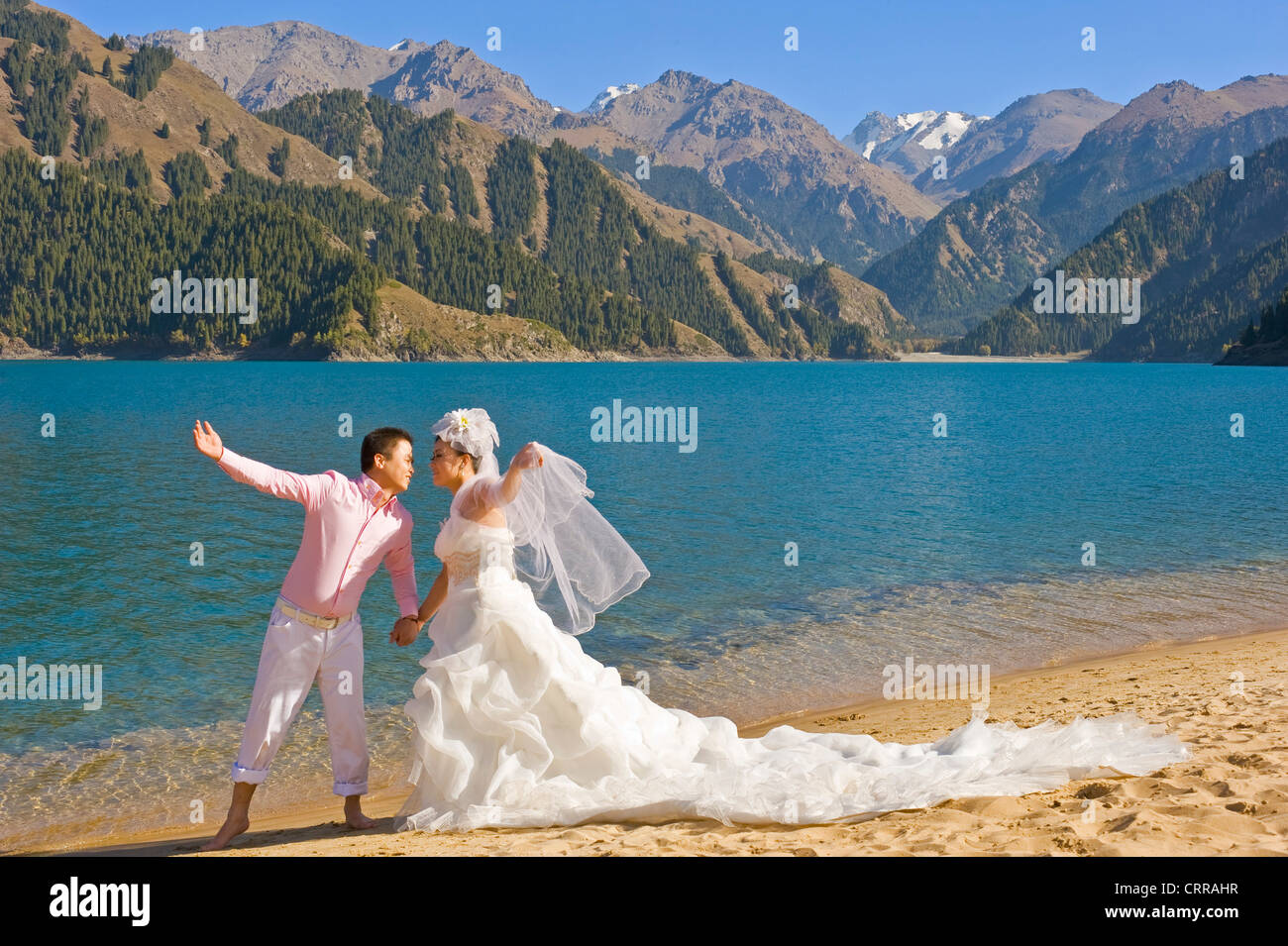 Ein chinesisches Ehepaar für ihre Hochzeitsfotos an der beliebten alpine Schönheit Stelle des himmlischen See darstellen. Stockfoto