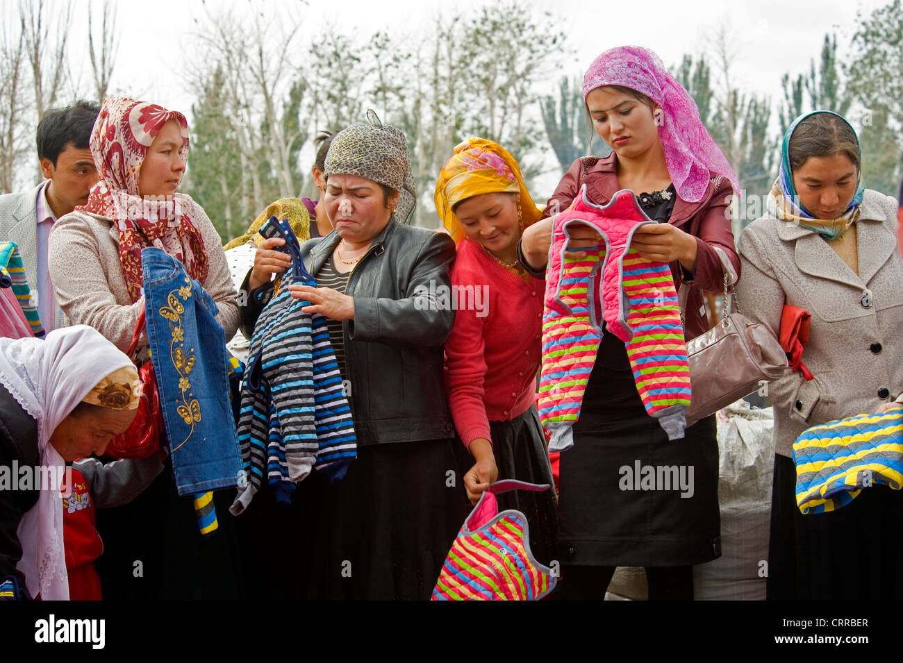 Uyghur Chinesinnen Kinderkleidung auf dem lokalen Markt in der kleinen Stadt von Upal in China zu kaufen. Stockfoto