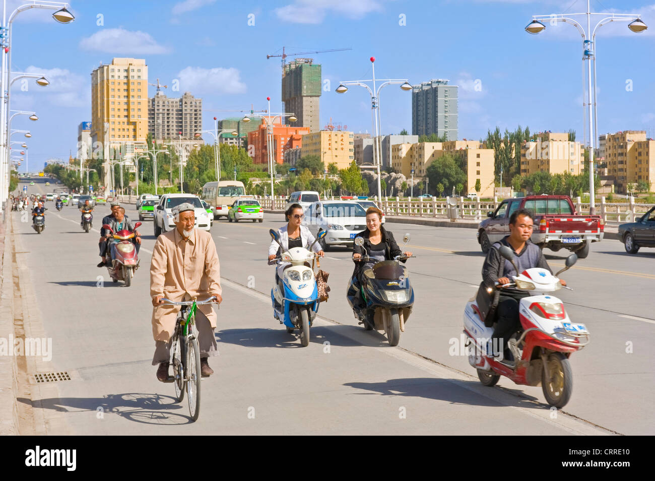 Ein Blick des Menschen auf Roller und Fahrräder Reisen entlang einer Hauptstraße in Kashgar. Stockfoto