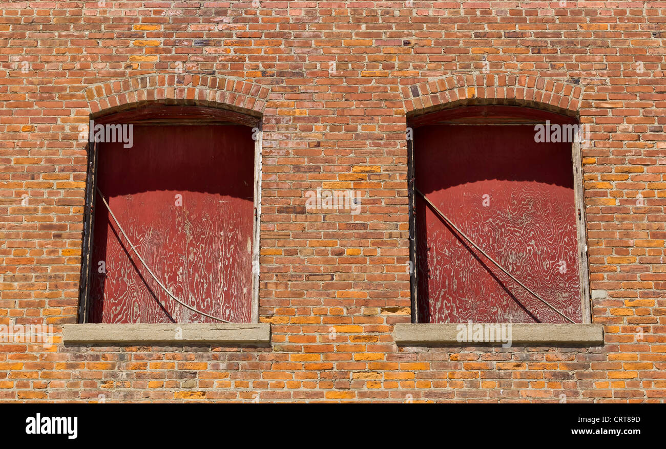 Alte Fenster auf einer roten Backsteinmauer Stockfoto