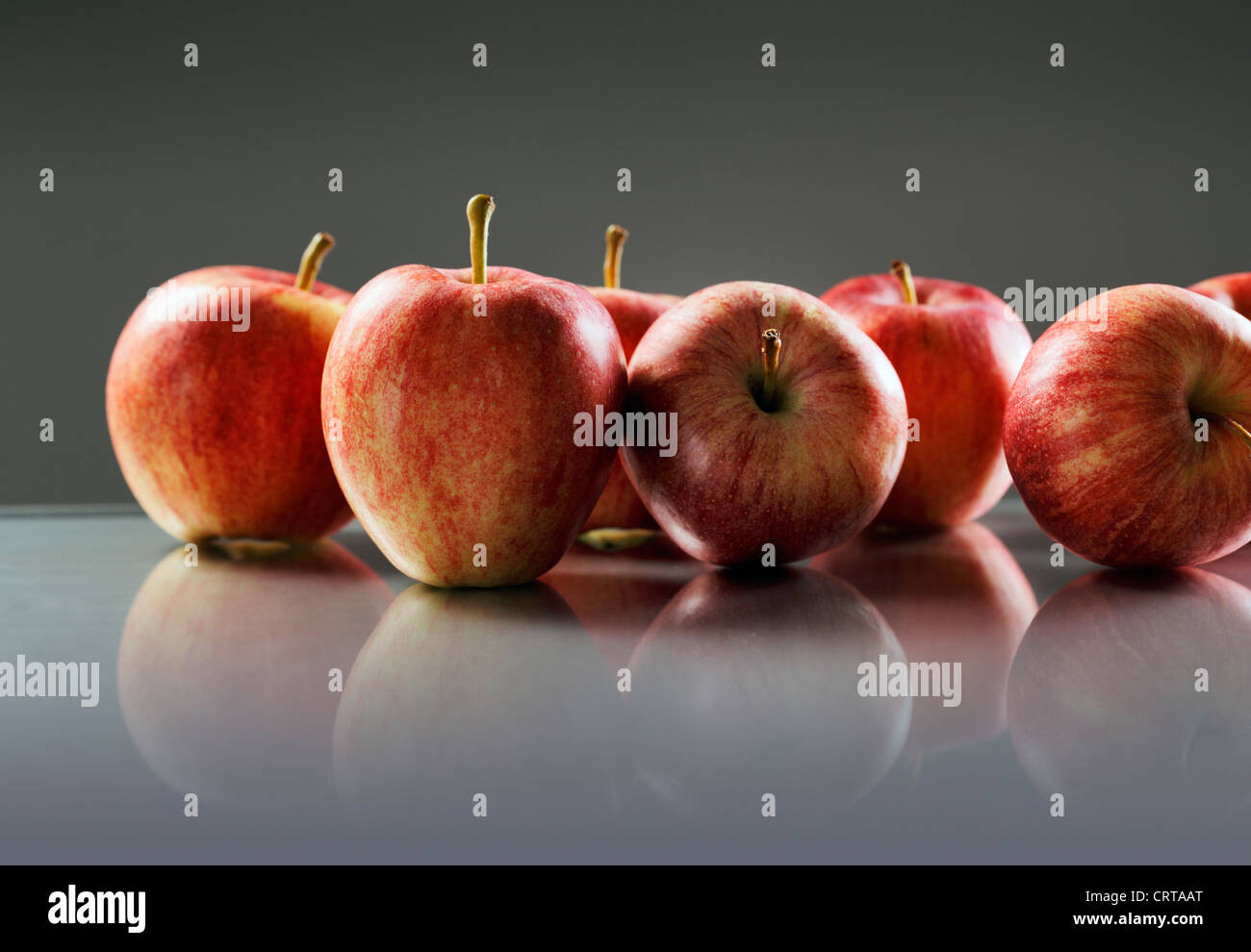 Rote Äpfel auf reflektierende Oberfläche. Stockfoto