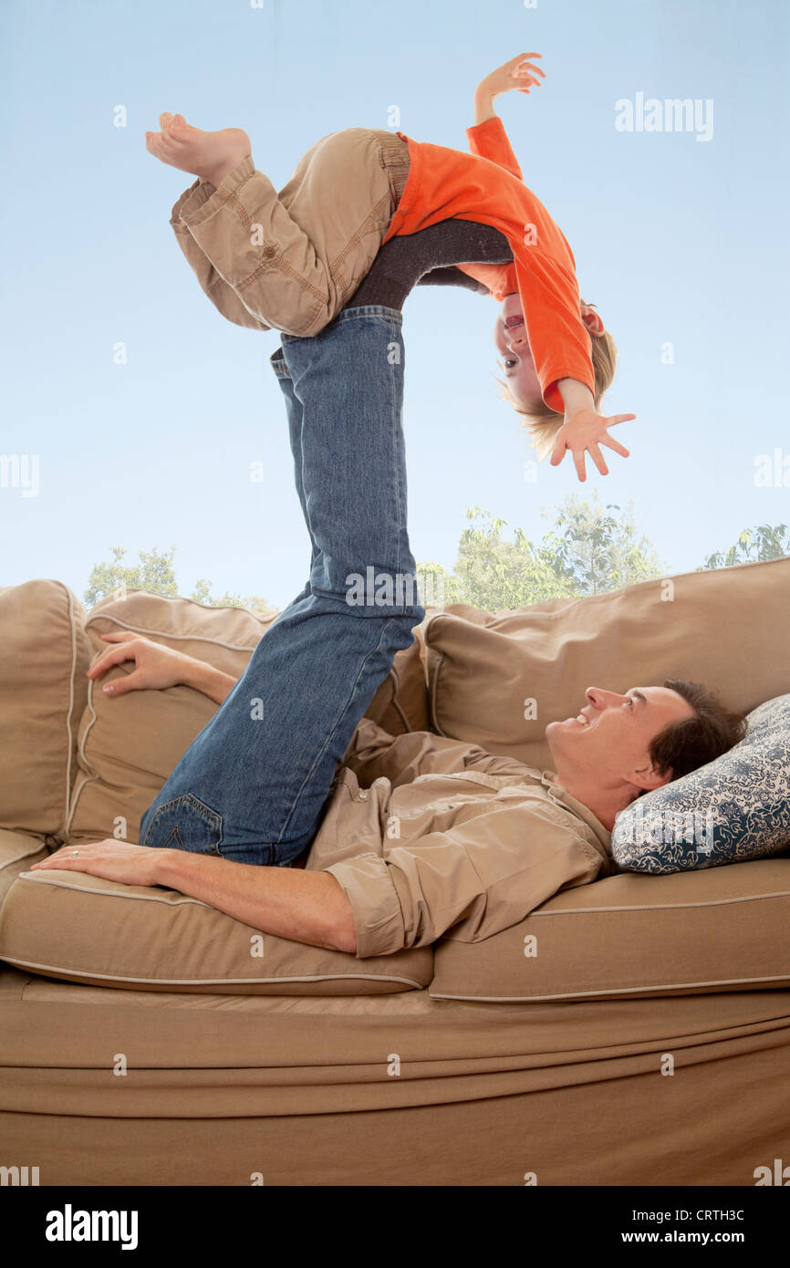 Vater mit seinem Sohn auf dem Sofa spielen. Stockfoto