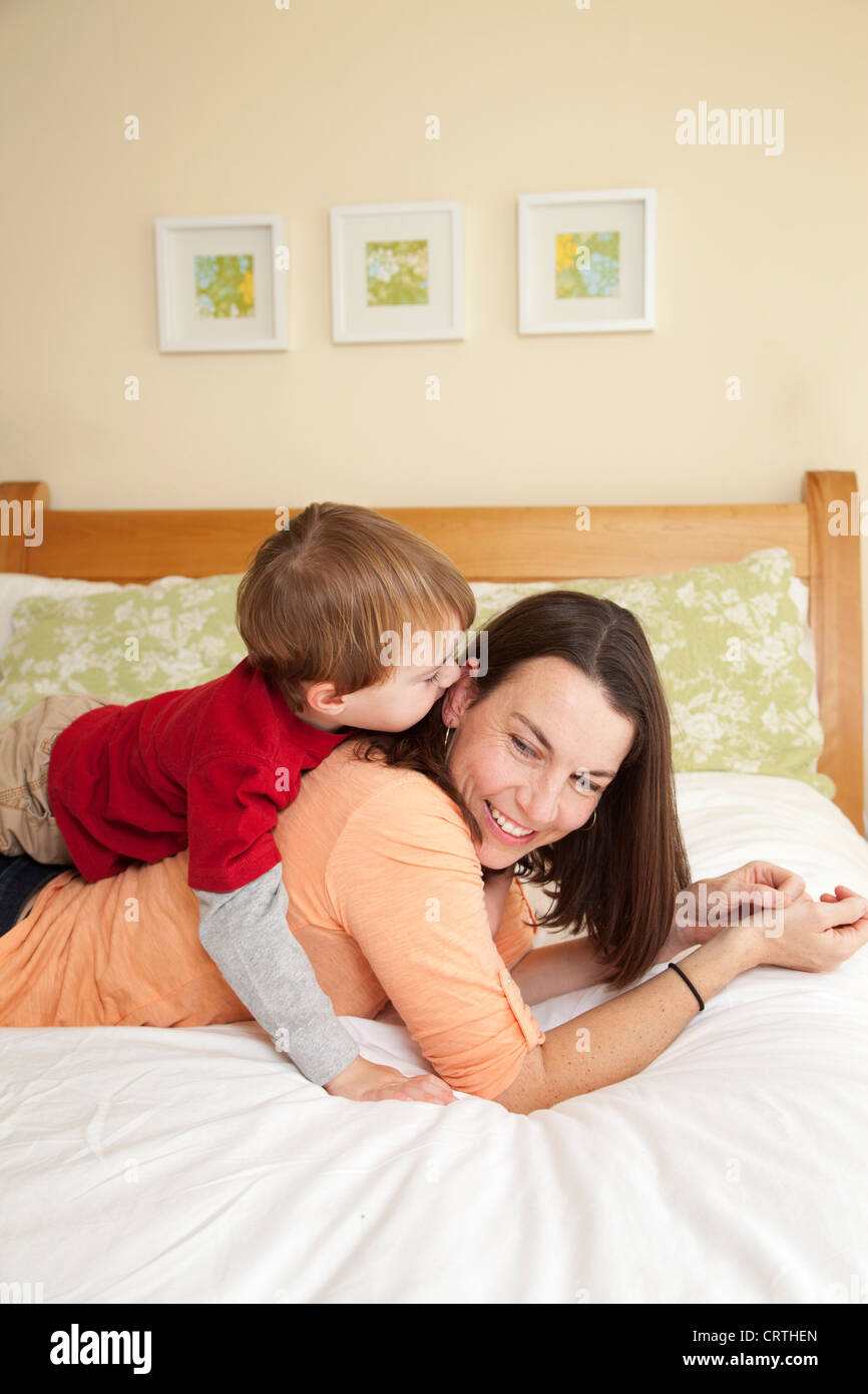 Mutter und Sohn auf dem Bett zusammen Lächeln auf den Lippen. Stockfoto