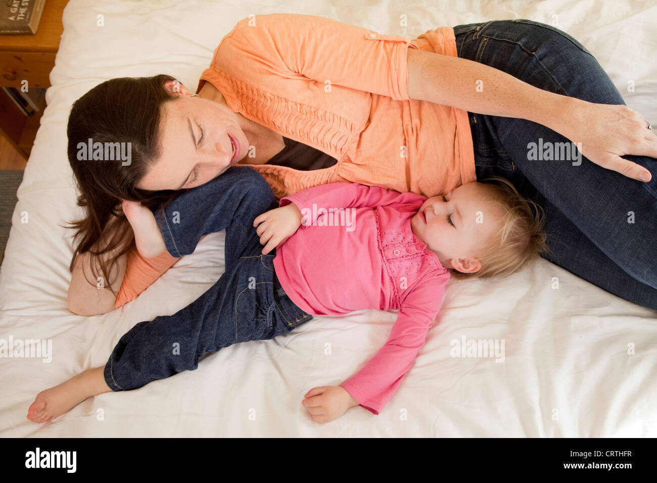 Eine Mutter und Tochter zusammen auf dem Bett liegend. Stockfoto