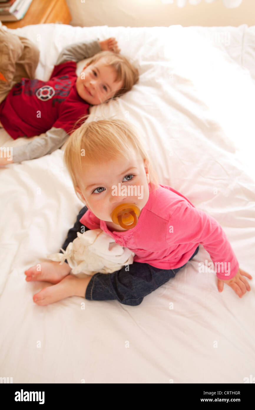 Kleine Mädchen und Jungen auf dem Bett zusammen. Stockfoto