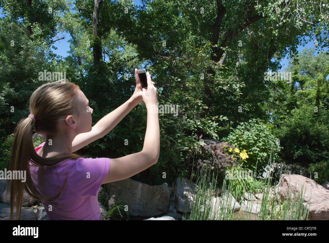 Ein 13 Jahres altes Mädchen nimmt ein Bild im Freien mit ihrer Iphone-Kamera. Stockfoto