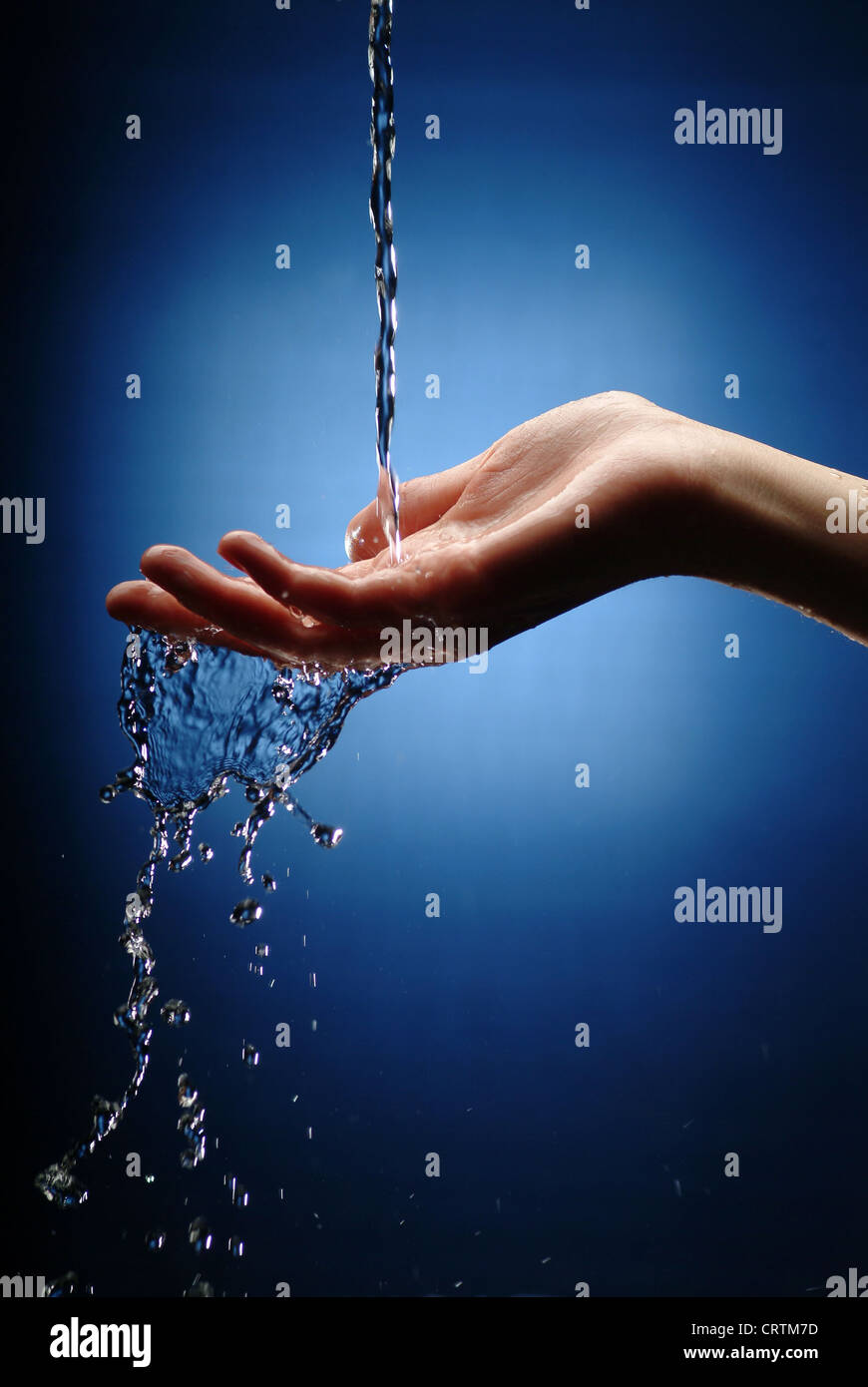 Zarte Frauenhand holt Wasserstrahl Stockfoto