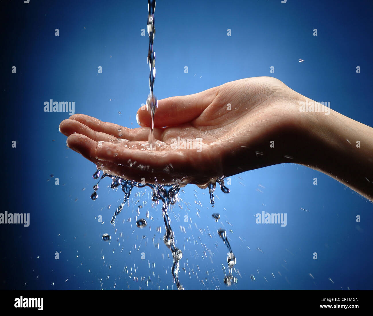 Zarte Frauenhand holt Wasserstrahl Stockfoto