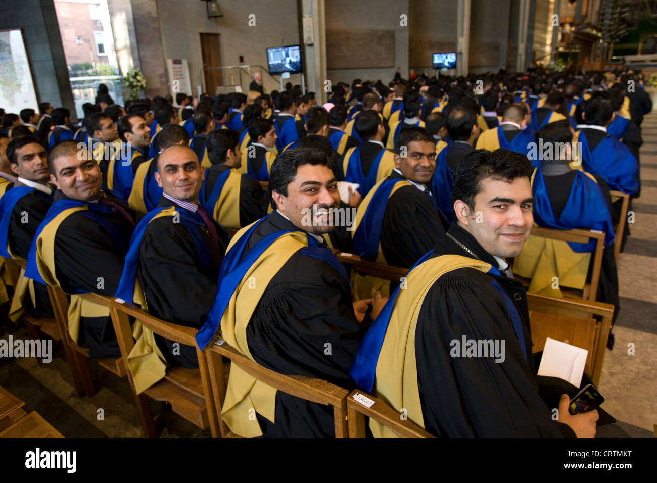 Absolventen aus Coventry University nehmen ihre Plätze in Coventry Kathedrale wo die Abschlussfeier stattfindet. Stockfoto