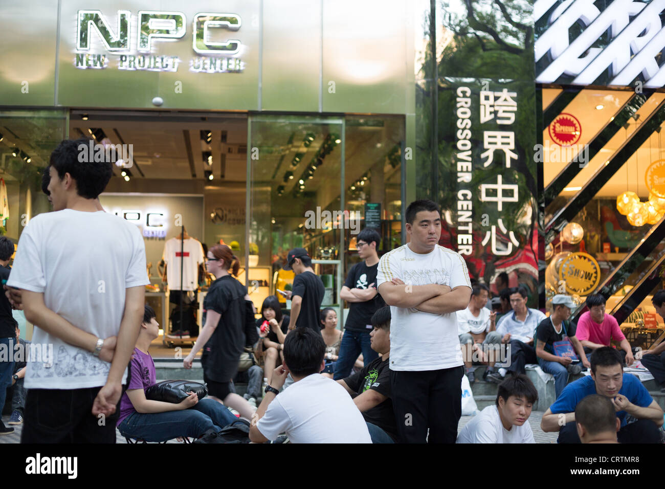 Chinesische Männer in die Warteschlange für einen Store Eröffnung in die gehobene Einkaufsviertel der Sanlitun in Beijing, China. Stockfoto