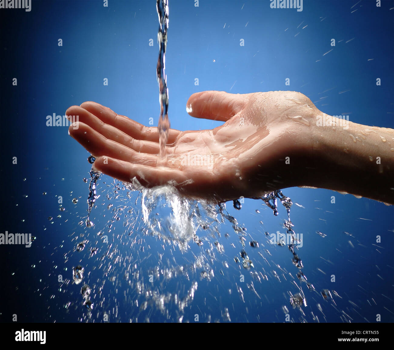 Zarte Frauenhand holt Wasserstrahl Stockfoto