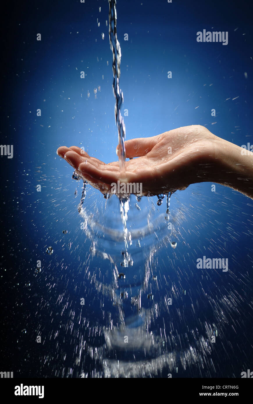 Zarte Frauenhand holt Wasserstrahl Stockfoto