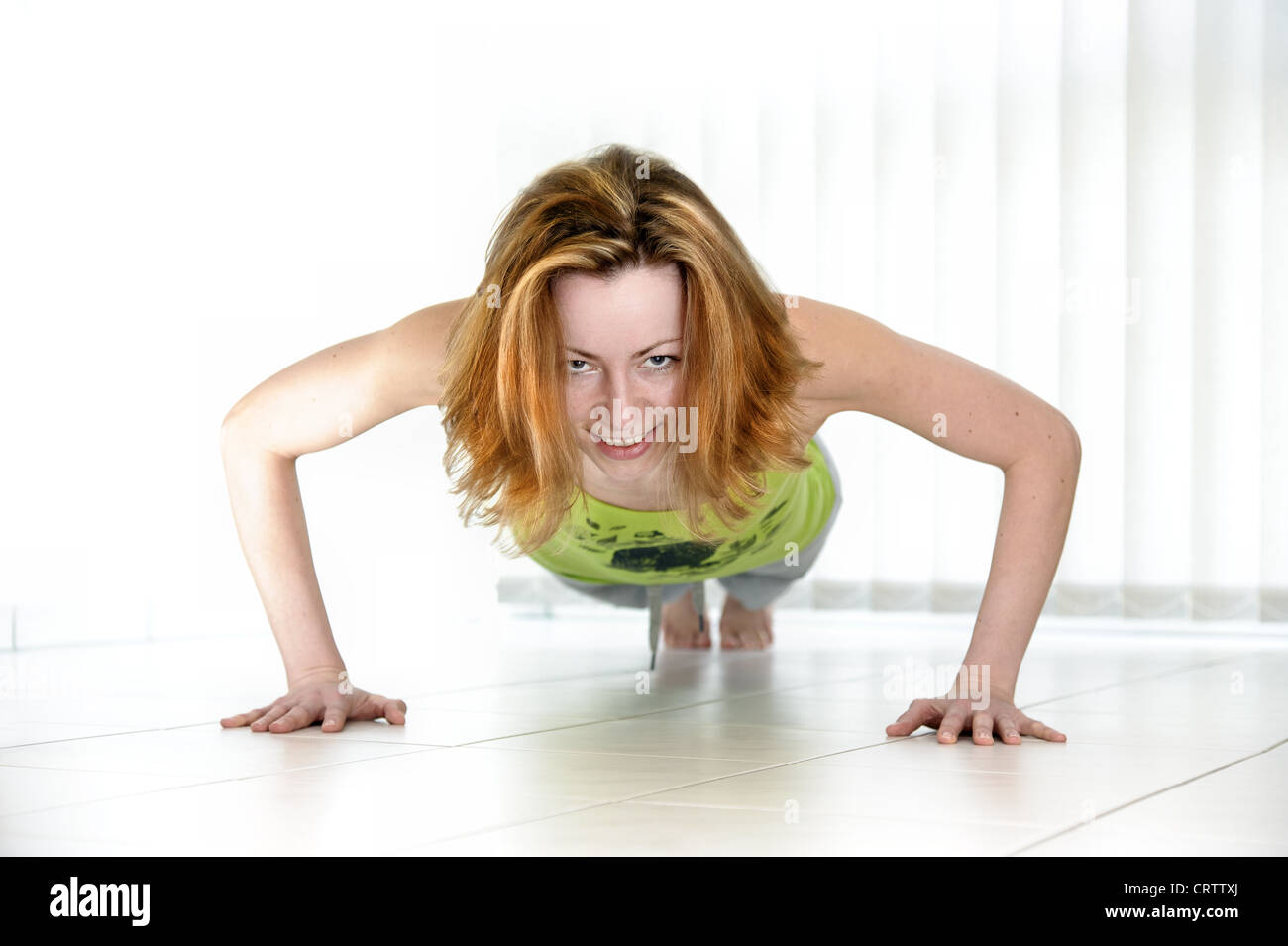 junge Frau macht Liegestütze auf dem Boden Stockfoto