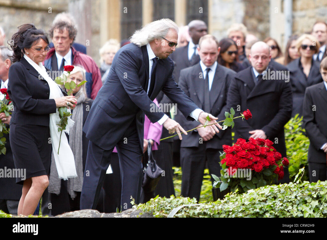 Barry Gibb (Mitte), Bruder von Robin Gibb, wirft eine Rose auf dem Sarg bei der Beerdigung von der Bee Gee-Sänger. Stockfoto