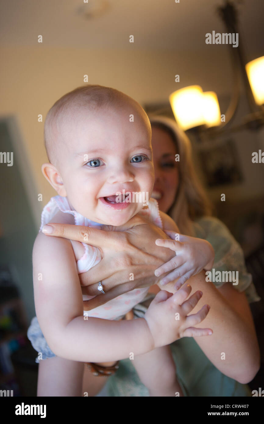 Mutter halten glückliches Baby Mädchen, sechs Monate alt. Stockfoto