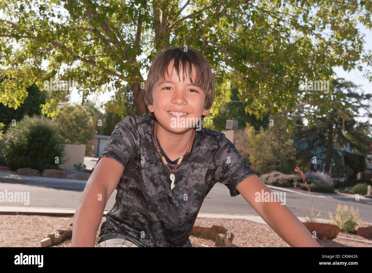 Dreizehn Jahre alten Hispanic Junge saß auf seinem Fahrrad und lächelt in die Kamera, Sommer. Stockfoto