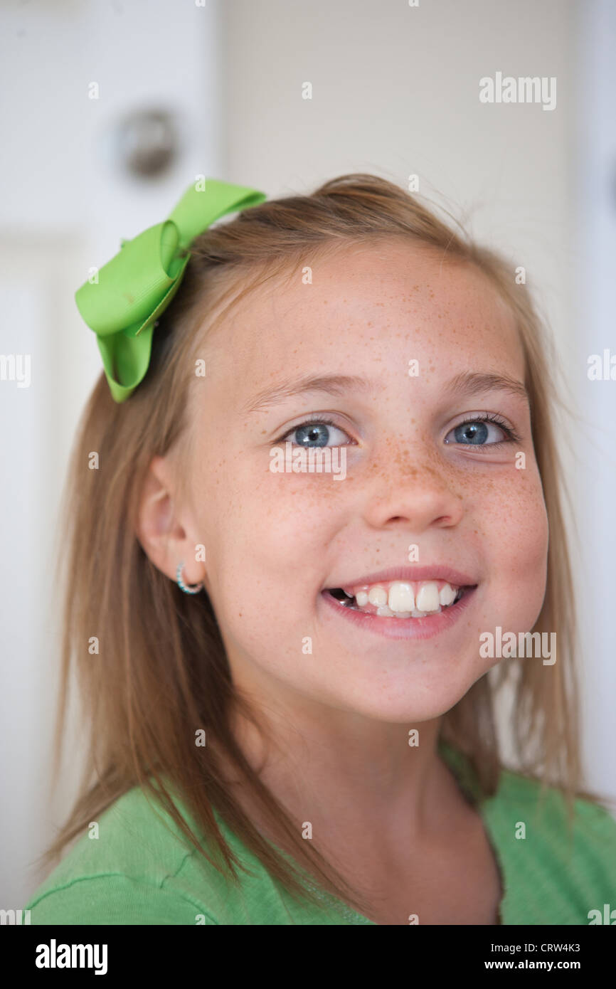 Glücklich neunjähriges Mädchen Swmiling trägt ein grünes Band. Stockfoto