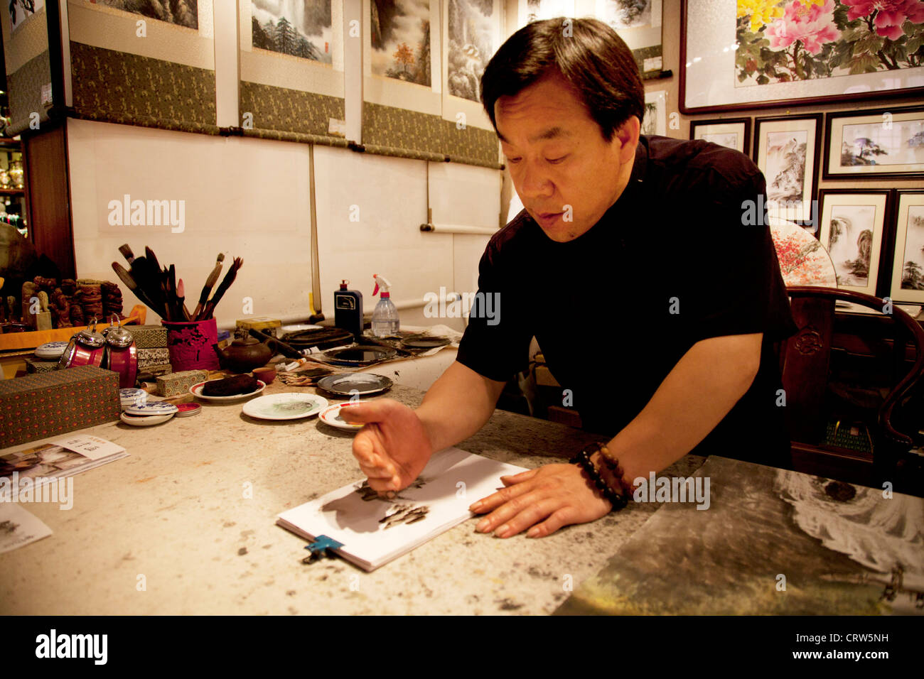 Künstler machen der traditionellen chinesischen Malerei mit verschiedenen Teilen seiner Hand statt einem Pinsel in seinem Atelier in Peking. Stockfoto