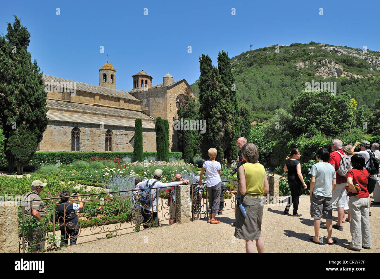 Touristen im Rosengarten der Abtei Abbaye Sainte-Marie de Fontfroide, Zisterzienserkloster im Languedoc, Pyrenäen, Frankreich Stockfoto