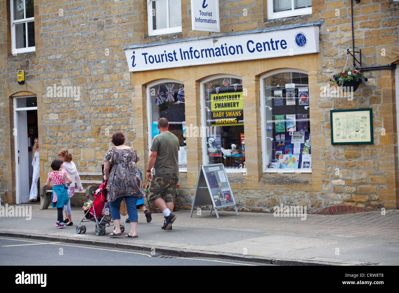 Familie zu Fuß vorbei an der Tourist Information Centre in Sherborne, Dorset im Juni Stockfoto