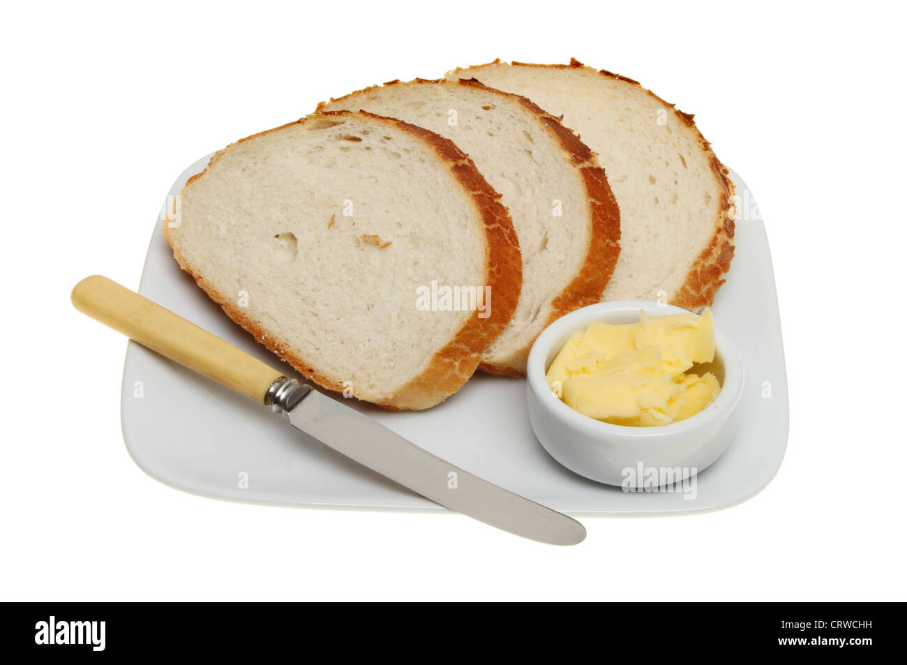 Brotscheiben auf einen Teller mit einem Messer und einem Töpfchen Butter isoliert gegen weiße giraffe Stockfoto