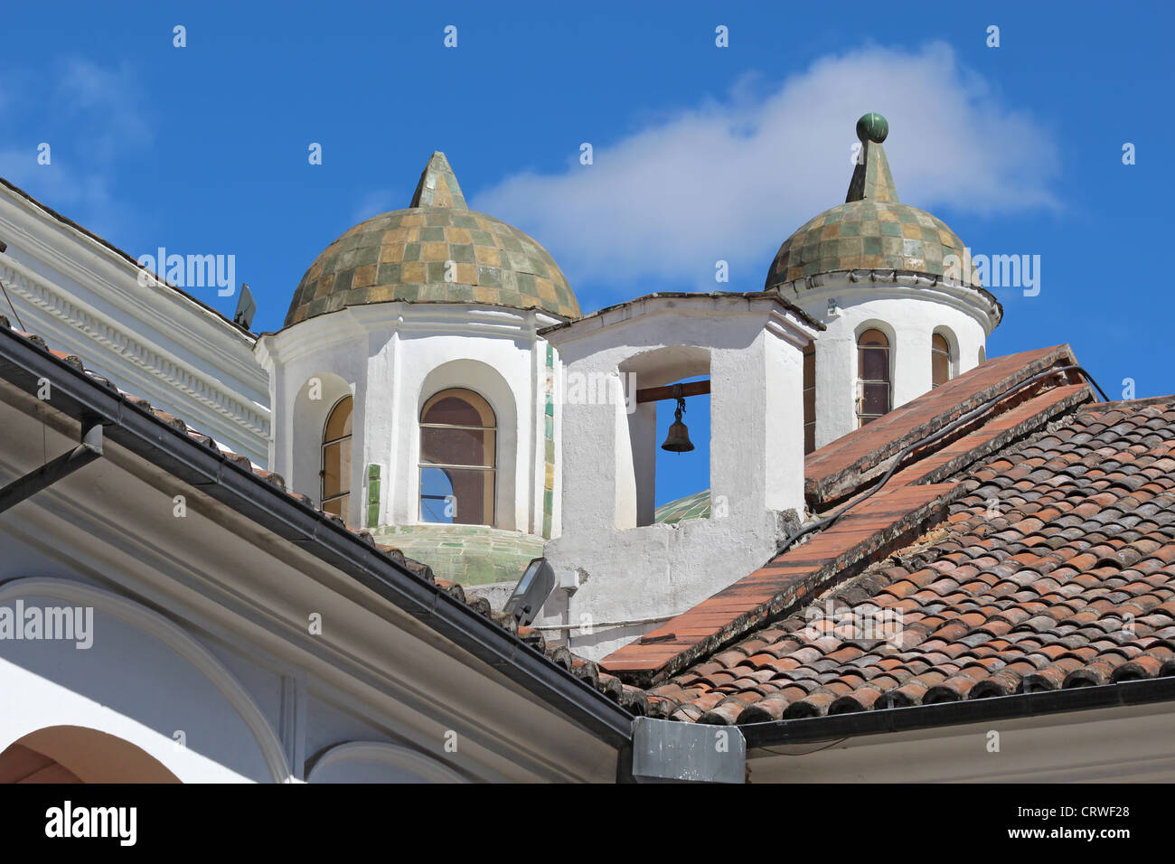 Nahaufnahme von Kuppeln und eine Glocke aus dem Hof der Kirche und des Klosters von San Francisco in Quito, Ecuador Stockfoto