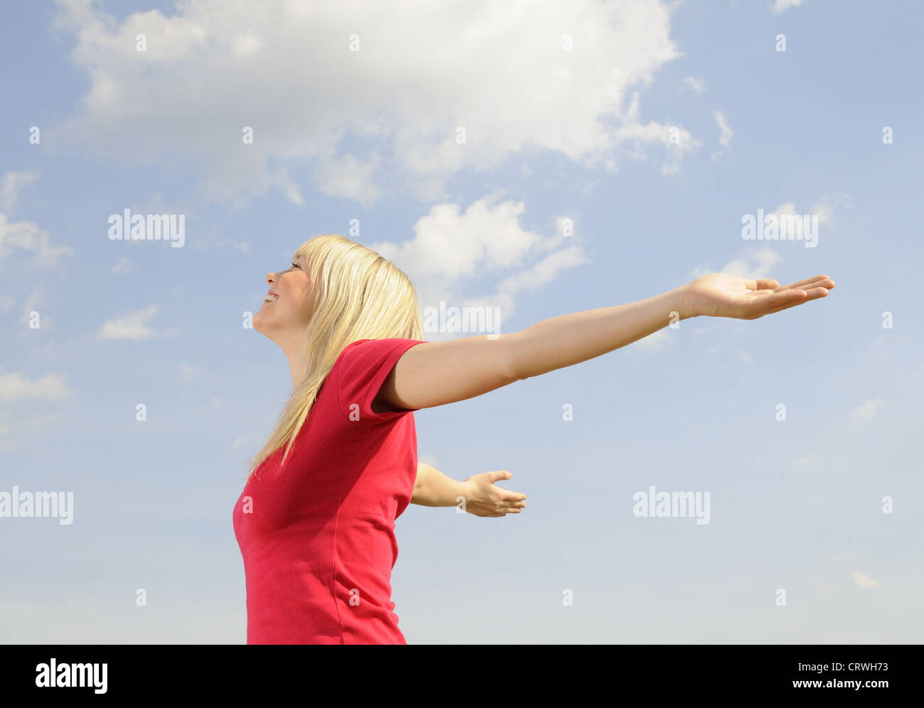 junge Frau breitet ihre Arme Stockfoto