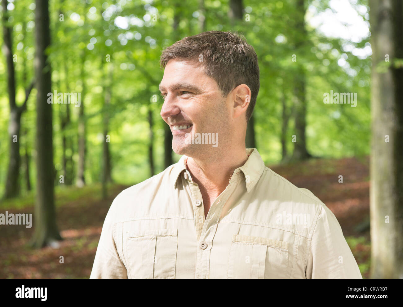 Lächelnder Mann ruht während einer Wanderung in der Natur Stockfoto