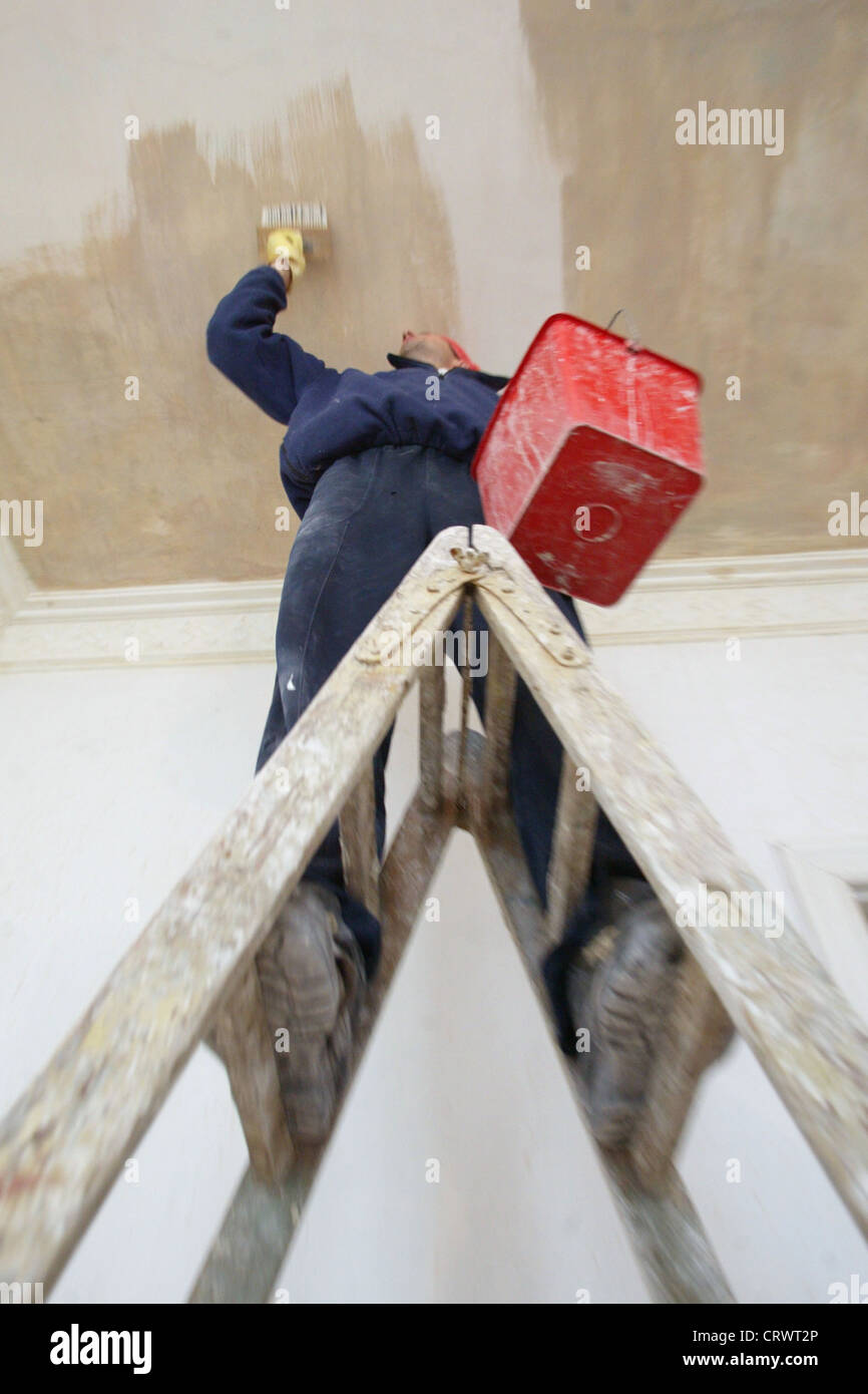 Mann auf einer Leiter bei der Renovierung Stockfoto