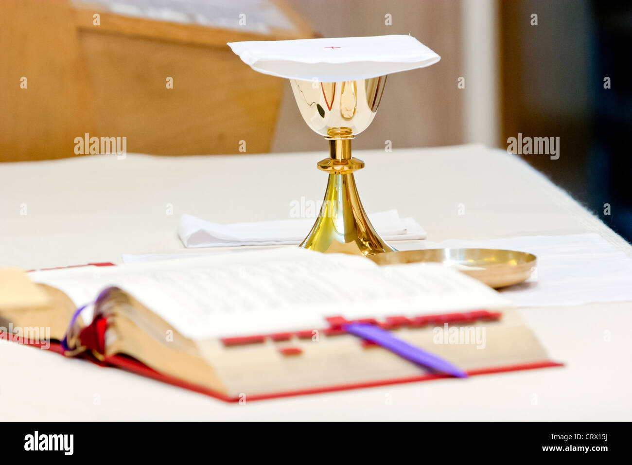 Katholische Masse, ein Kelch und ein Gebetbuch während der religiösen Zeremonie. Stockfoto