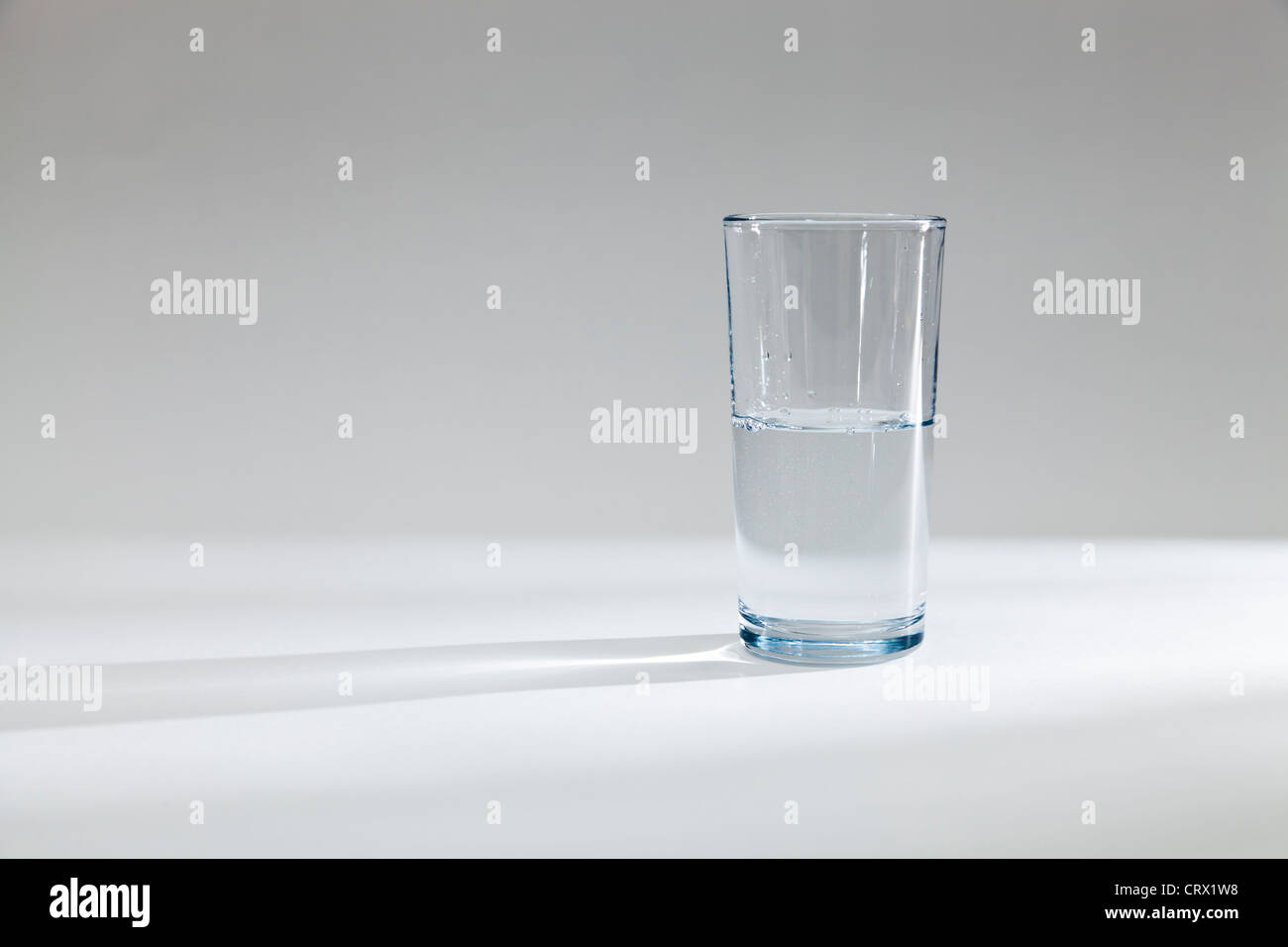Glas halb voll oder halb leer mit Wasser Stockfoto