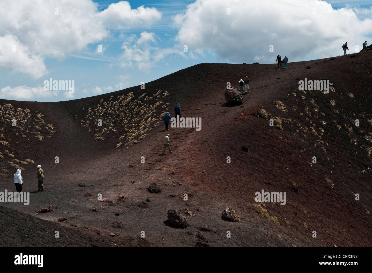 Touristen besuchen die Silvestri Krater in der Nähe der Rifugio Sapienza auf 1900m auf dem Ätna, Sizilien, Italien - die rote Lava ist reich an Eisen Stockfoto