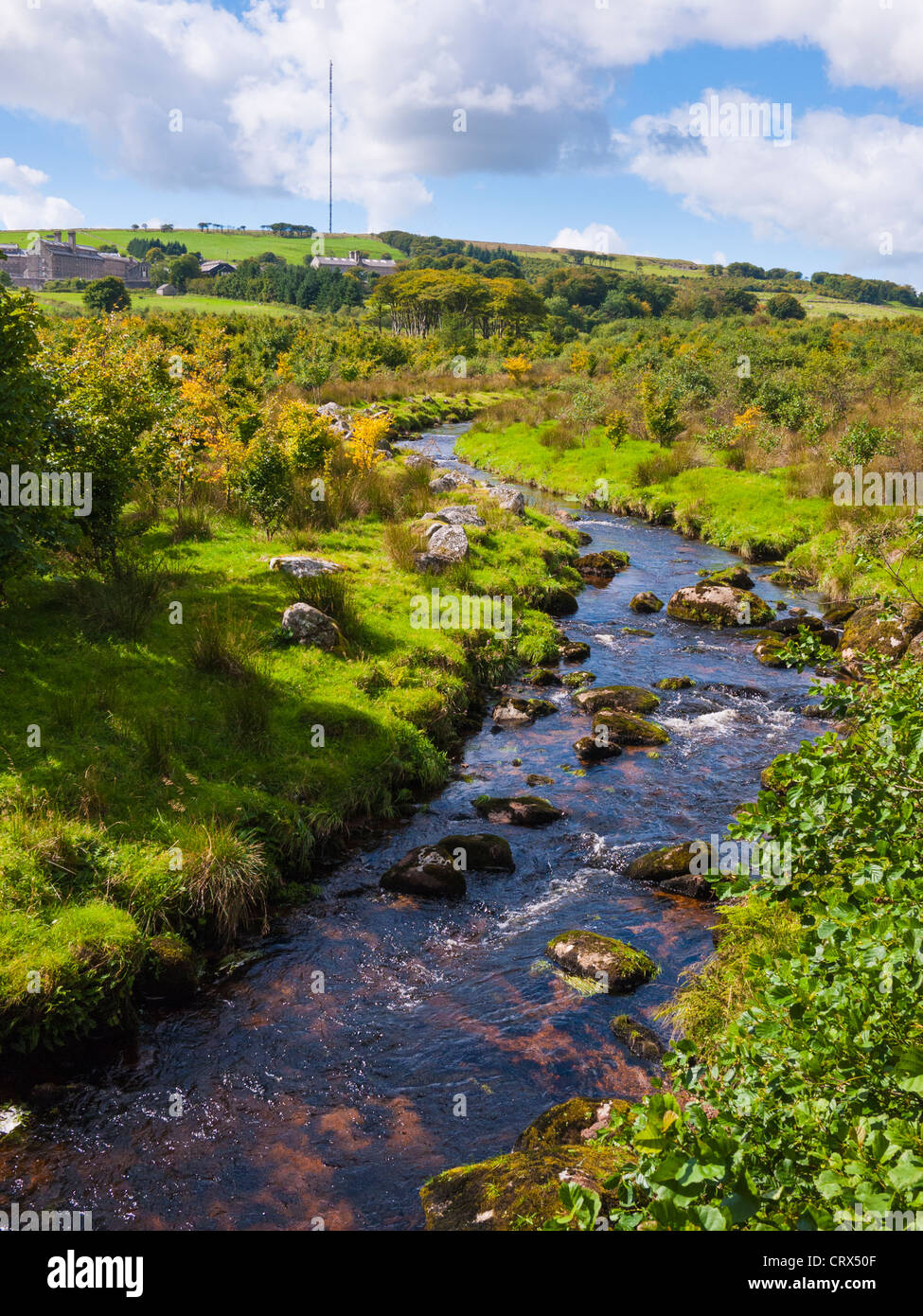 Blackbrook River in der Nähe von Princetown im Nationalpark Dartmoor, Devon, England. In der Ferne ist Dartmoor prison und North Hessary Tor. Stockfoto