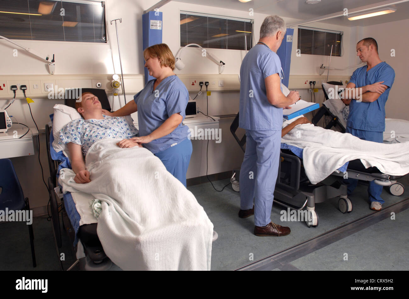 Ärzte auf ihre Krankenstation Runden im Gespräch mit Patienten. Stockfoto
