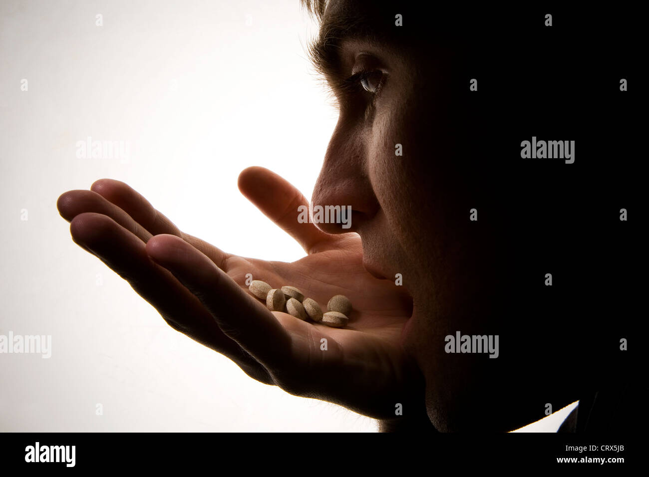 Ein depressiv junger Mann mit einer Handvoll Schlaftabletten. Stockfoto