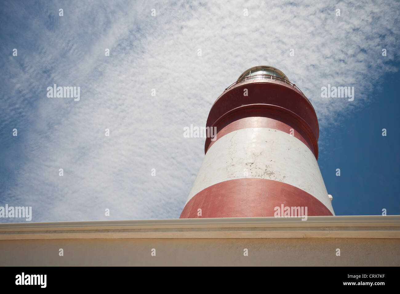 Cape Agulhas Lichthaus mit einem blauen Himmel und streifenweißen Wolken. Kap Agulhas, Westkap, Südafrika Stockfoto