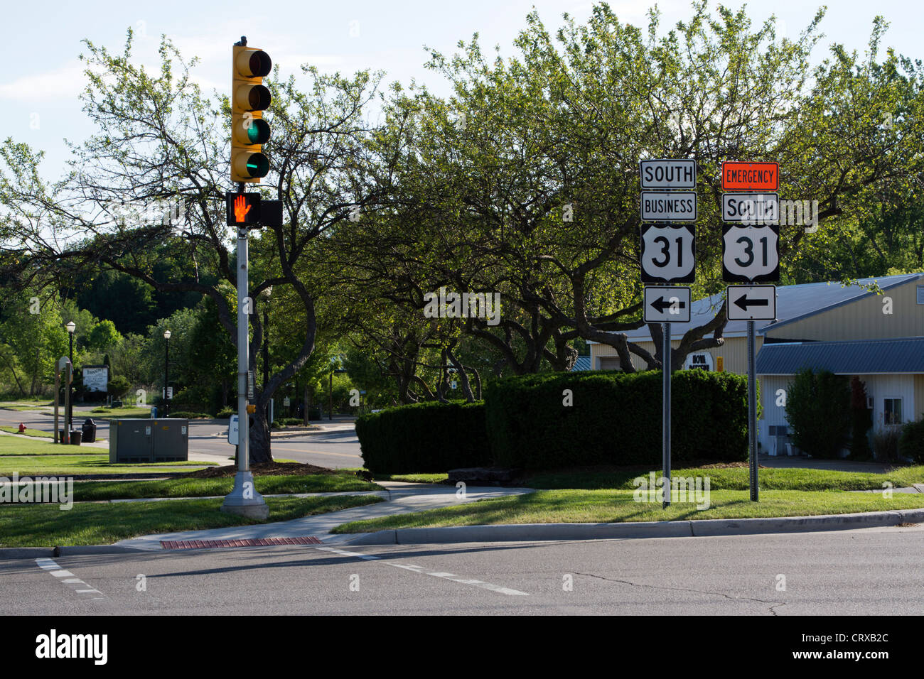 Ampel auf einer Straße Post in einer kleinen Stadt USA.  Autobahn-Schilder weisen die Richtung.  Licht ist grün, aber "Don ' t walk" signalisieren. Stockfoto