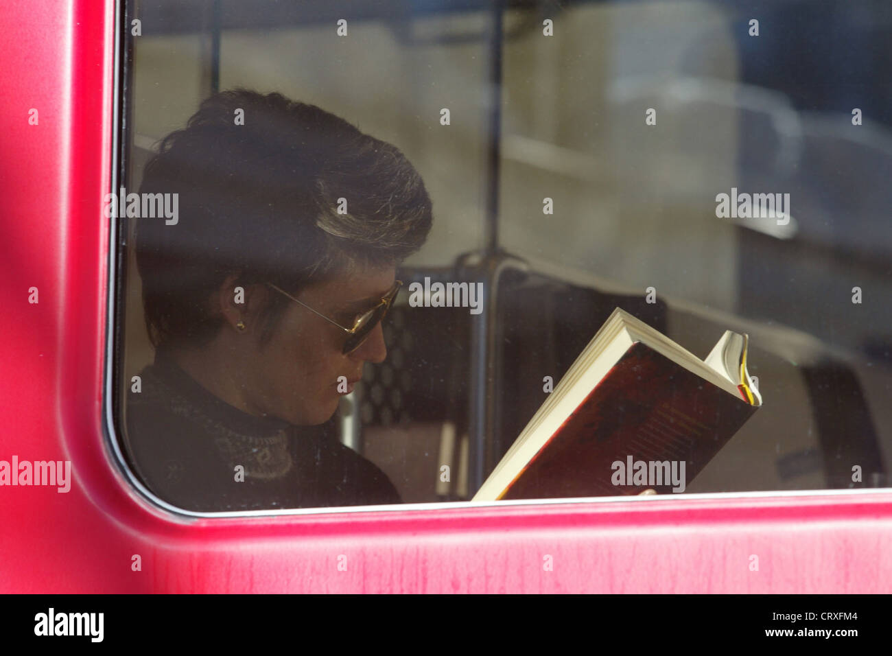 Eine Frau liest ein Buch in einem Zug Stockfoto