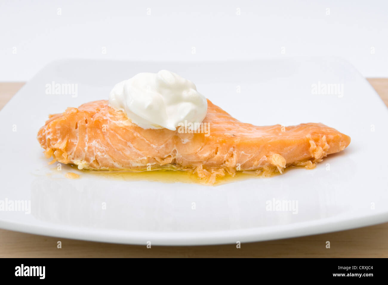 Gekochter Lachs mit Klecks Creme Fraiche und zerlassener Butter auf ...