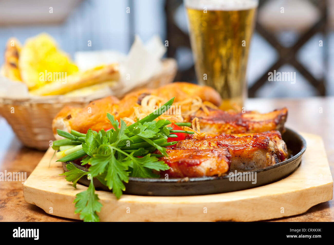 Gegrillte Schweinerippchen und Gemüse hautnah. Mit Brot und Bier im ...