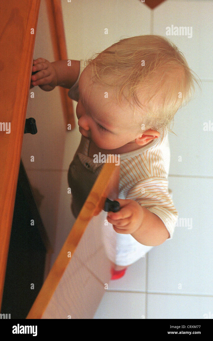 Ein neugieriges Kind steckt seinen Kopf in einen Schaltschrank Stockfoto