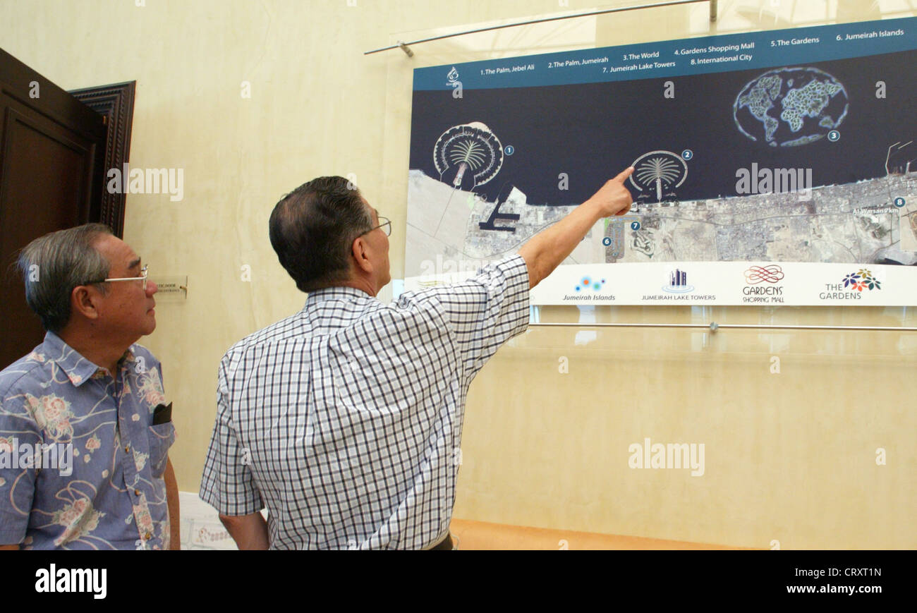 Touristen besuchen eine simulierte Satellitenfoto der Bauvorhaben The World und The Palm, Dubai Stockfoto