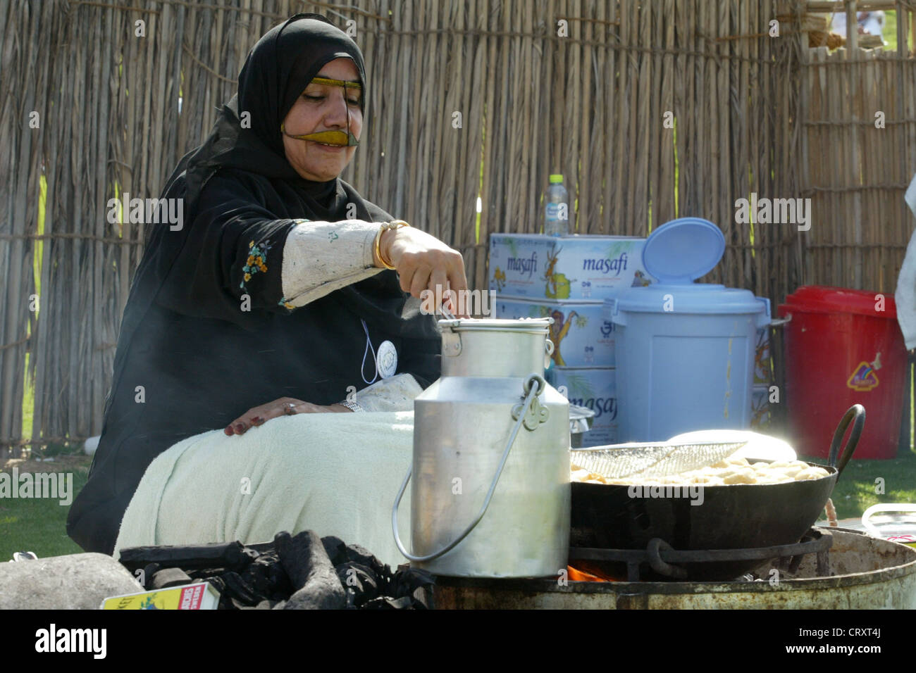 Eine verschleierte Frau beim Kochen, Dubai Stockfoto