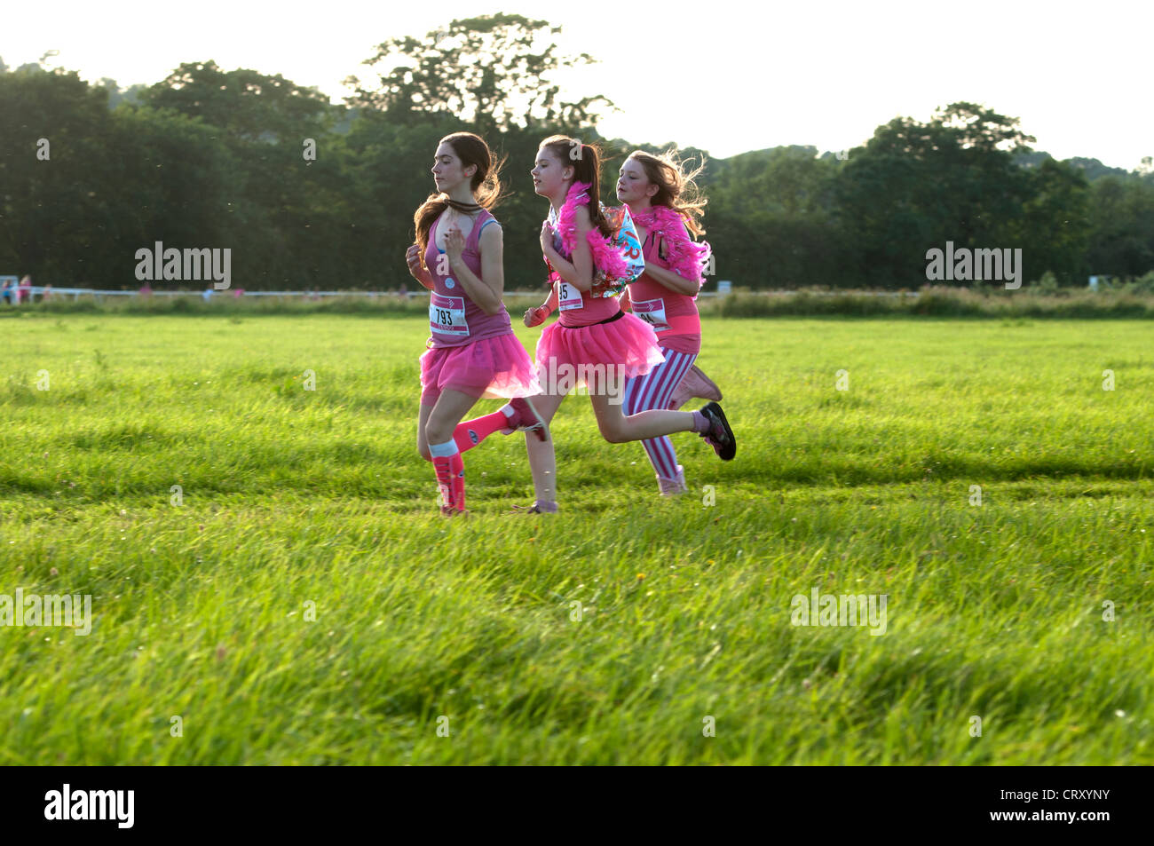 Mädchen im Race for Life in Stratford Rennbahn laufen. Stockfoto