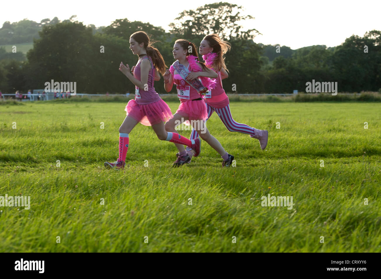 Mädchen im Race for Life in Stratford Rennbahn laufen. Stockfoto