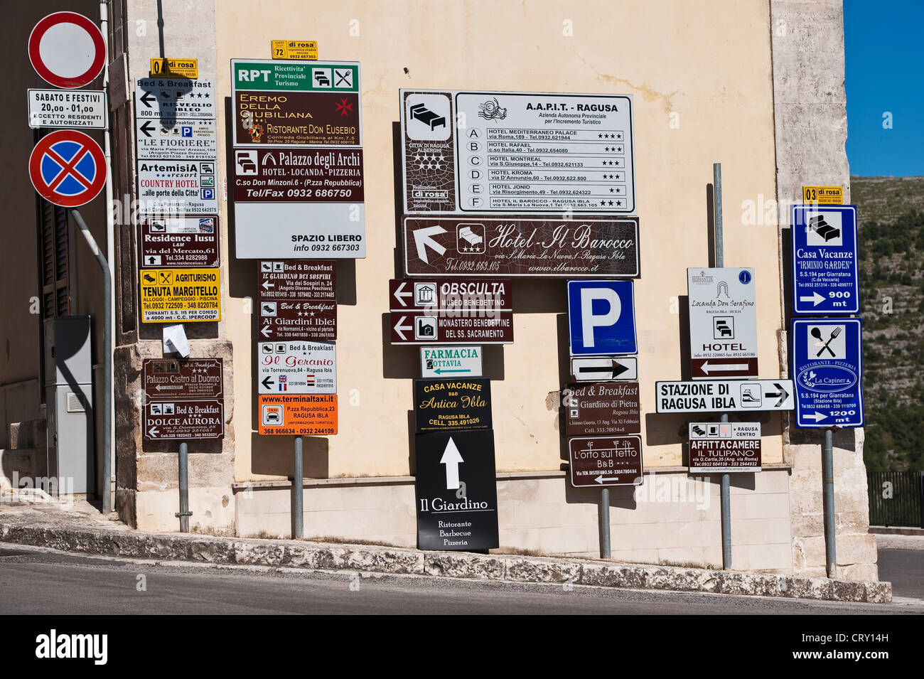 Eine verwirrende Anzeige von Straßenschildern und Werbung am Eingang der Stadt Ragusa, Sizilien, Italien Stockfoto