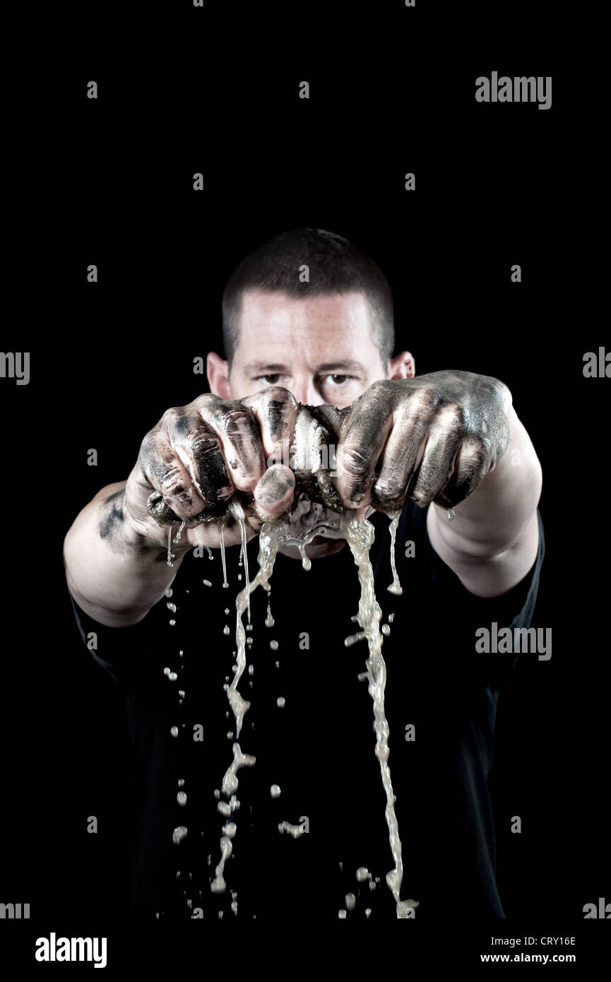 Ein Mann ringt sich ein schmutziges Wasser getränkten Lappen mit Grunge, schmutzige Hände. Schwerpunkt liegt auf den Händen und Lappen. Stockfoto
