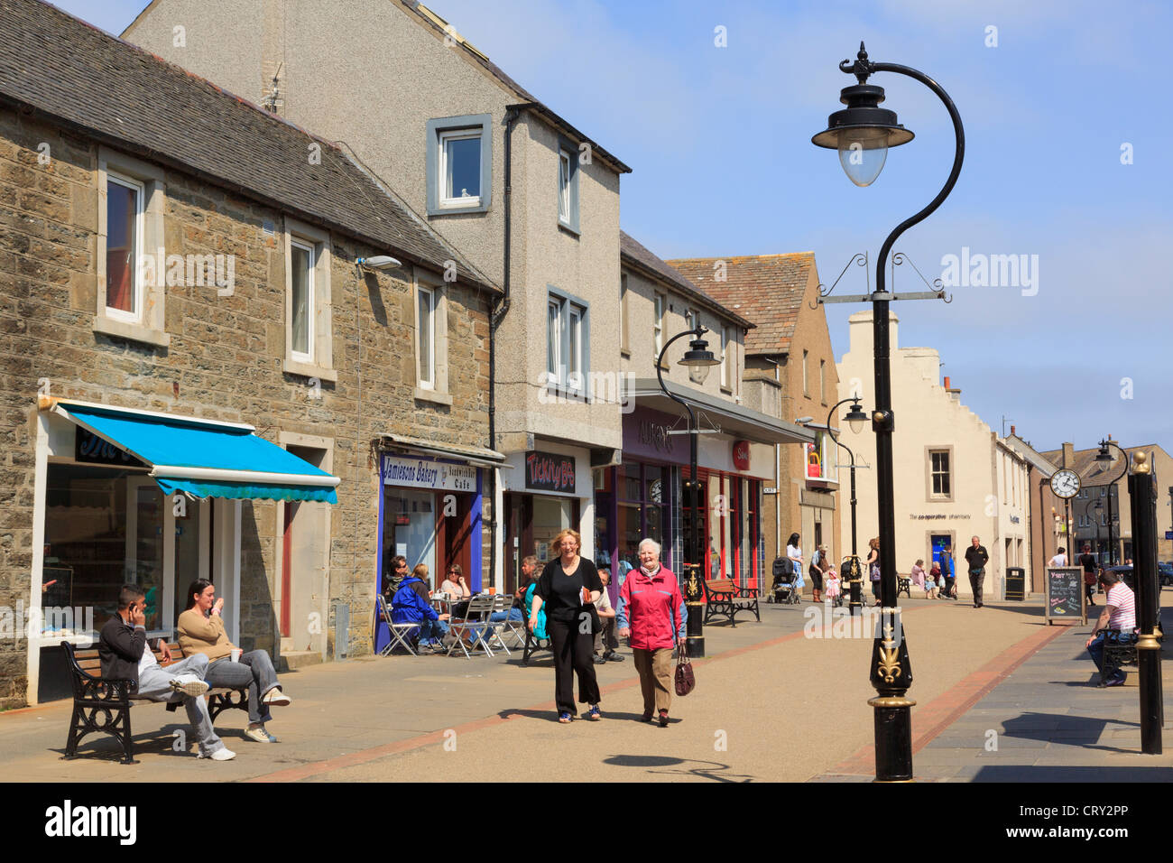 Straßenszene mit kleinen Geschäften und Menschen beim Einkaufen in der Innenstadt. High Street, Thurso, Caithness, Schottland, UK, Großbritannien. Stockfoto