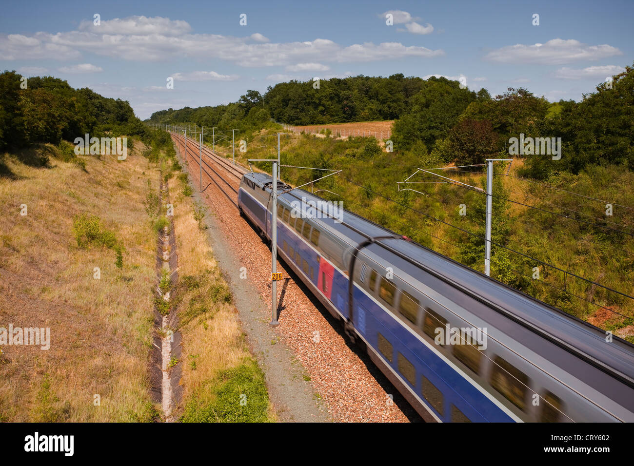 Ein Doppeldecker TGV beschleunigt durch die französische Landschaft. Stockfoto